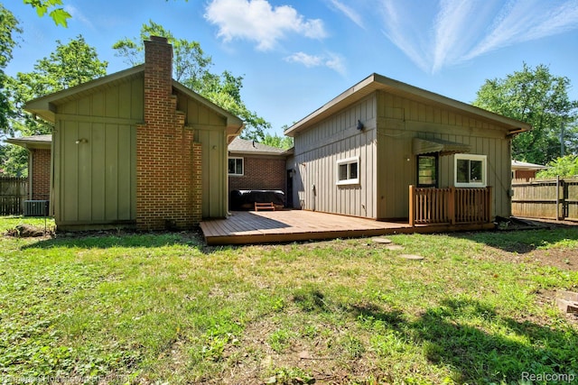 42424 Bradner Ct, Plymouth, MI 48170 - rear view of house with board and batten siding, a chimney, a deck, and brick siding