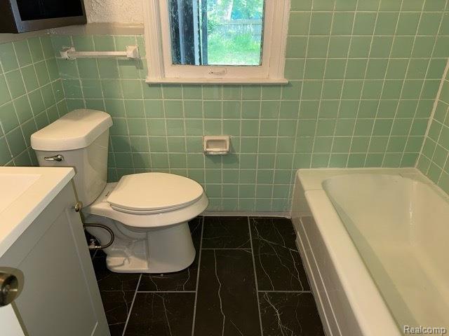 25895 Annapolis St, Dearborn Heights, MI 48125 - full bathroom featuring a tub, vanity, marble finish flooring, and tile walls