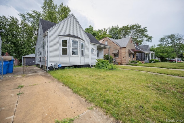 25895 Annapolis St, Dearborn Heights, MI 48125 - view of front facade featuring a front yard, an outdoor structure, a garage, and roof with shingles