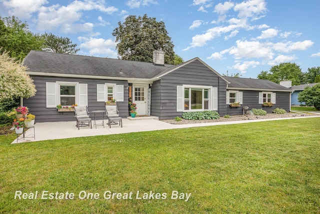4185 Shattuck Rd, Saginaw, MI 48603 - back of property featuring a chimney, a patio area, and a yard