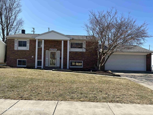 11424 Hazel Ave, Grand Blanc, MI 48439 - bi-level home featuring brick siding, an attached garage, a front lawn, concrete driveway, and a chimney