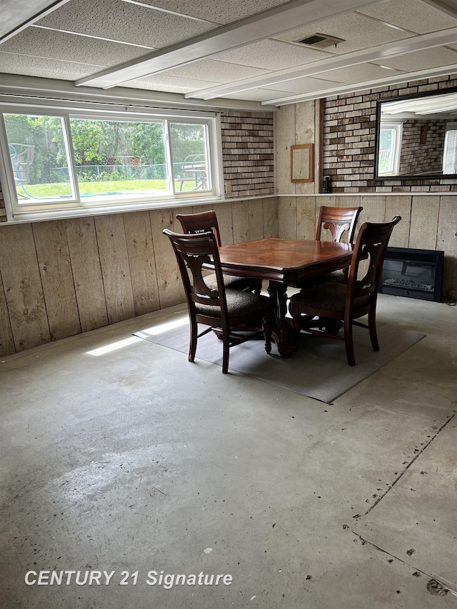 11424 Hazel Ave, Grand Blanc, MI 48439 - dining area with unfinished concrete floors and wooden walls
