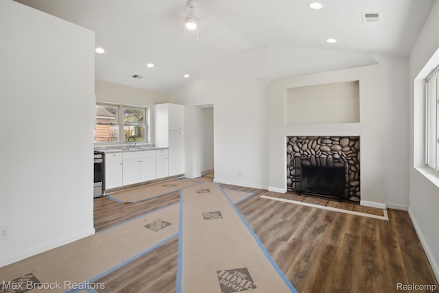 165 W Colgate Ave, Pontiac, MI 48340 - unfurnished living room with vaulted ceiling, light wood-style flooring, recessed lighting, and a stone fireplace