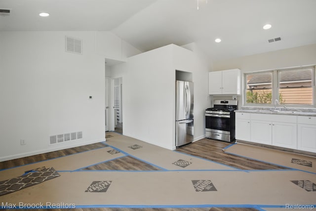 165 W Colgate Ave, Pontiac, MI 48340 - kitchen with appliances with stainless steel finishes, vaulted ceiling, white cabinetry, dark wood-type flooring, and light countertops