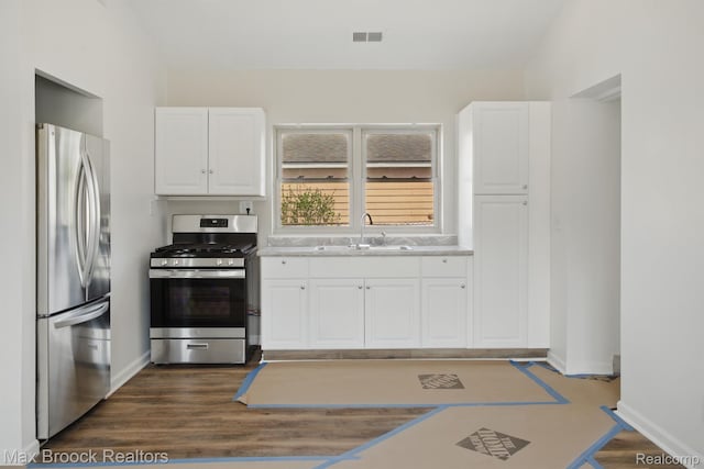 165 W Colgate Ave, Pontiac, MI 48340 - kitchen with stainless steel appliances, white cabinetry, light countertops, and dark wood-type flooring