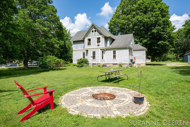 409 W Bridge St, Lyons, MI 48851 - rear view of house with a fire pit, a yard, and roof with shingles