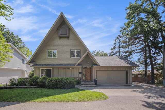117 High View Ct, Brooklyn, MI 49230 - view of front facade with board and batten siding, an attached garage, concrete driveway, a front yard, and a shingled roof