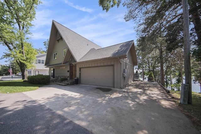 117 High View Ct, Brooklyn, MI 49230 - view of side of home featuring board and batten siding, concrete driveway, a shingled roof, and an attached garage