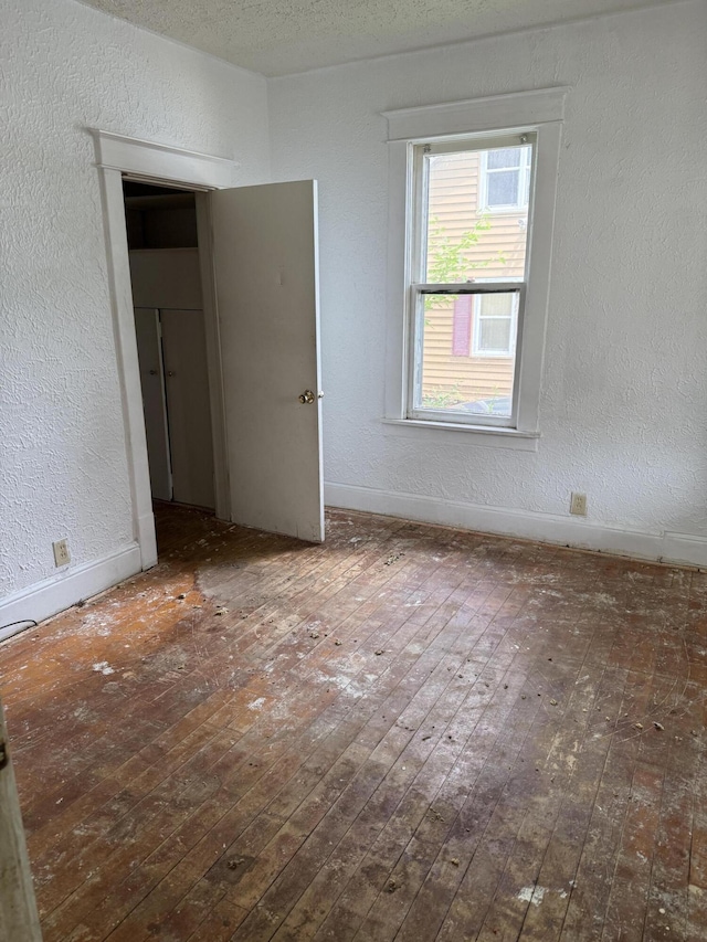 774 Amity Ave, Muskegon, MI 49442 - spare room featuring hardwood / wood-style flooring and a textured wall