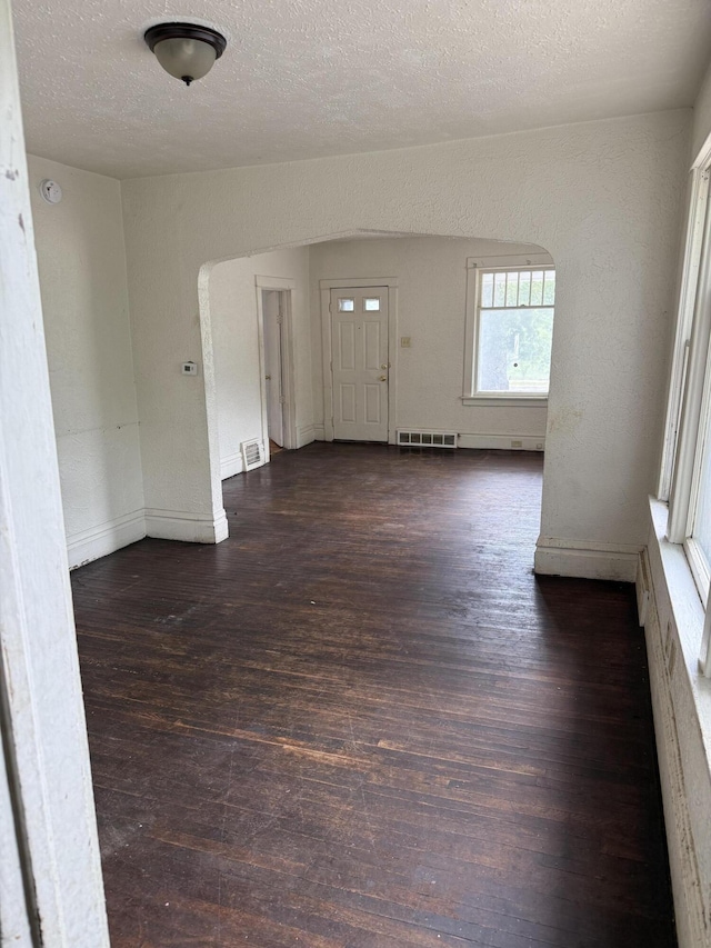774 Amity Ave, Muskegon, MI 49442 - spare room featuring wood finished floors, a textured ceiling, and arched walkways