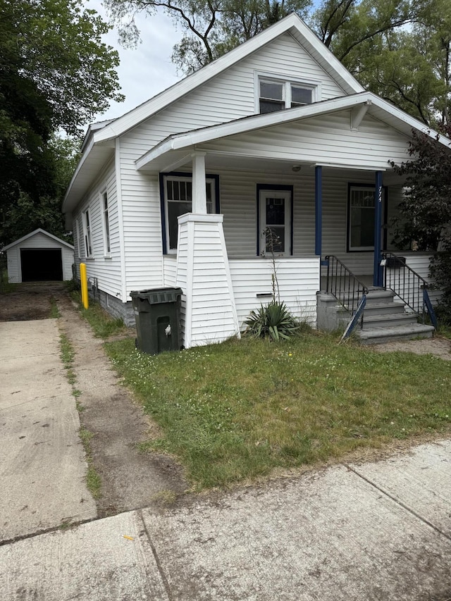 774 Amity Ave, Muskegon, MI 49442 - view of front of property with concrete driveway, an outdoor structure, a detached garage, and a porch