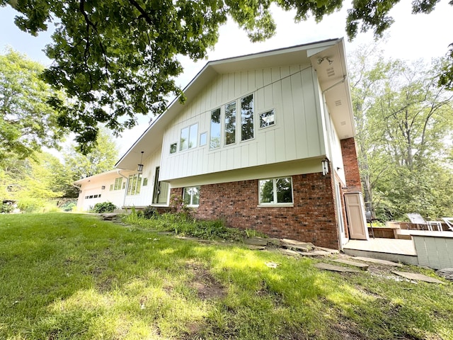 2277 W Huron River Dr, Ann Arbor, MI 48103 - back of house with brick siding, a lawn, and a garage