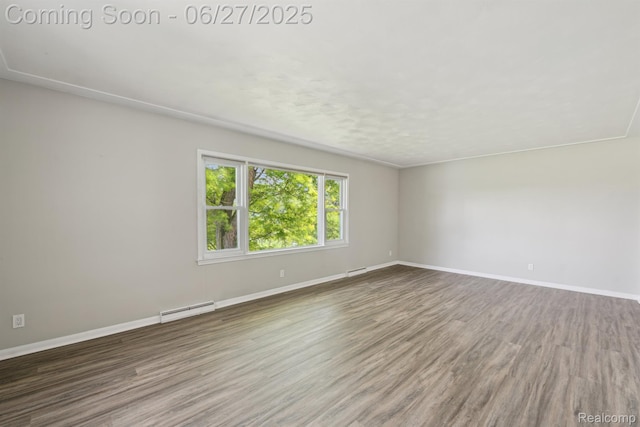 15501 Turner, Lansing, MI 48906 - spare room featuring a baseboard heating unit and wood finished floors