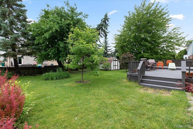 18068 Autumn Ln, Macomb, MI 48044 - fenced yard featuring a storage shed and a deck