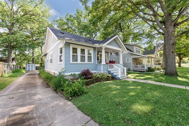 809 Pauline Blvd, Ann Arbor, MI 48103 - view of front of house with a porch, a storage shed, a front yard, and a shingled roof