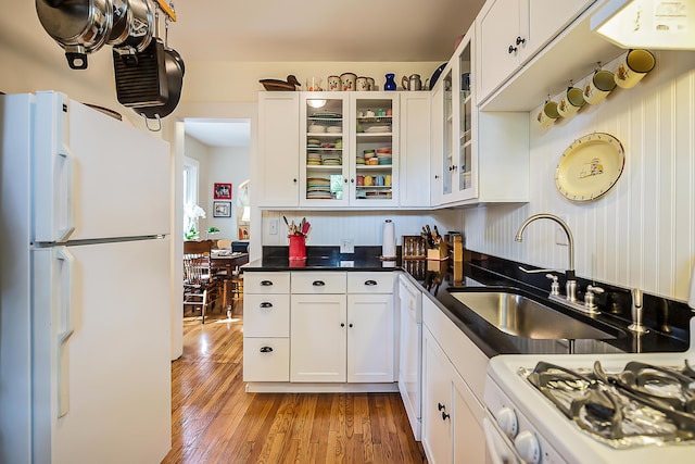 809 Pauline Blvd, Ann Arbor, MI 48103 - kitchen featuring white appliances, white cabinetry, light wood-style flooring, dark countertops, and glass insert cabinets
