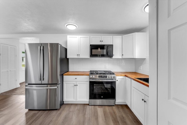 521 E Morrell St, Otsego, MI 49078 - kitchen featuring appliances with stainless steel finishes, wooden counters, light wood finished floors, white cabinetry, and a textured ceiling