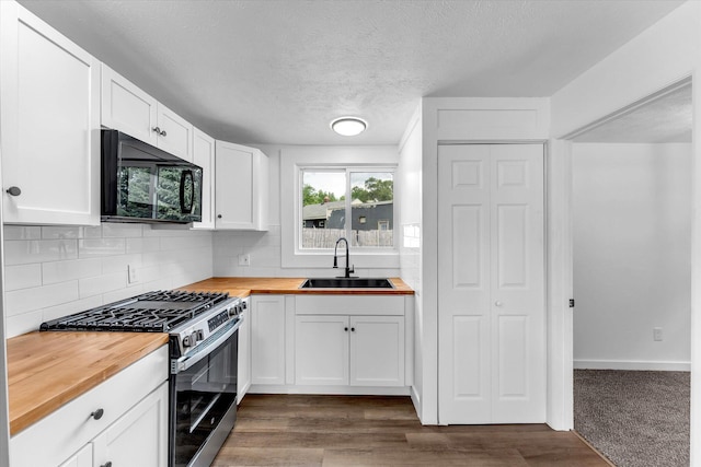 521 E Morrell St, Otsego, MI 49078 - kitchen with butcher block countertops, black microwave, gas range, decorative backsplash, and white cabinets