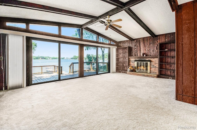 2058 S Long Lake Rd, Fenton, MI 48430 - unfurnished living room featuring wood walls, a water view, carpet, a textured ceiling, and a ceiling fan