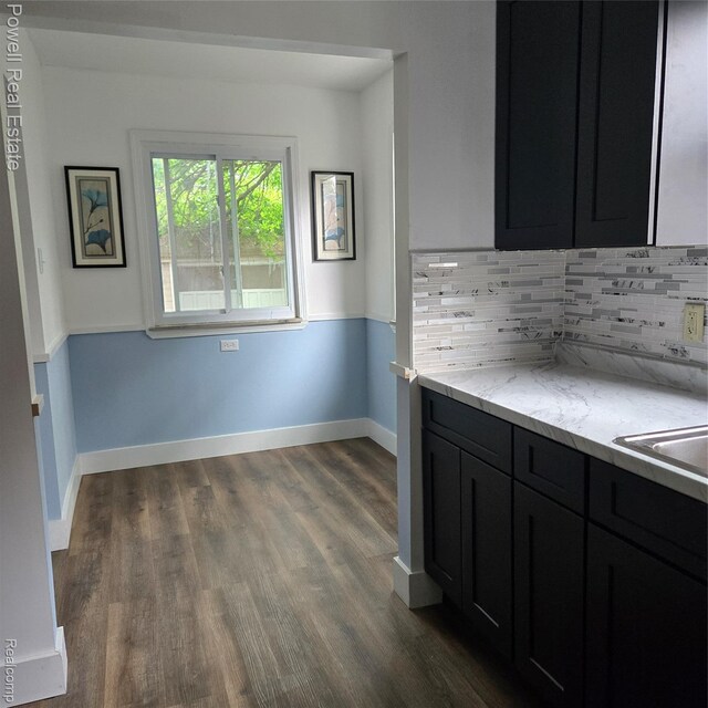 4670 Devonshire Rd, Detroit, MI 48224 - kitchen with dark cabinetry, dark wood finished floors, decorative backsplash, and light stone counters