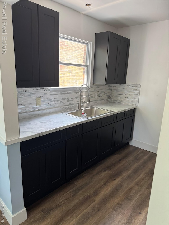 4670 Devonshire Rd, Detroit, MI 48224 - kitchen featuring decorative backsplash, dark wood-type flooring, dark cabinetry, and light stone counters