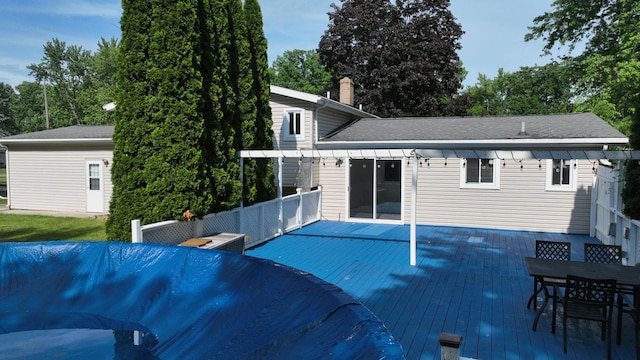 11427 Colonial Woods Dr, Clio, MI 48420 - back of property with outdoor dining area, a deck, a chimney, and roof with shingles