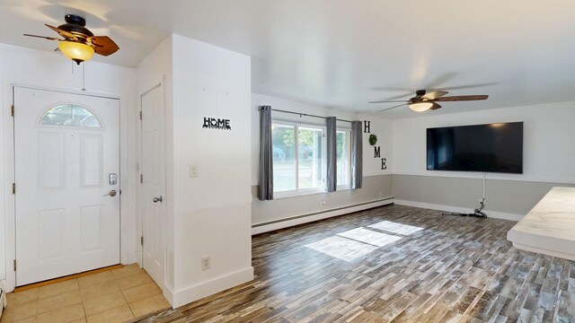 11427 Colonial Woods Dr, Clio, MI 48420 - foyer entrance featuring a baseboard heating unit, a ceiling fan, and light wood finished floors