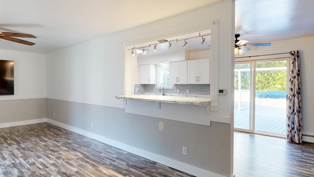11427 Colonial Woods Dr, Clio, MI 48420 - kitchen with ceiling fan, wood finished floors, white cabinetry, and tasteful backsplash