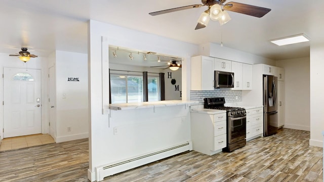 11427 Colonial Woods Dr, Clio, MI 48420 - kitchen with appliances with stainless steel finishes, a baseboard radiator, and ceiling fan