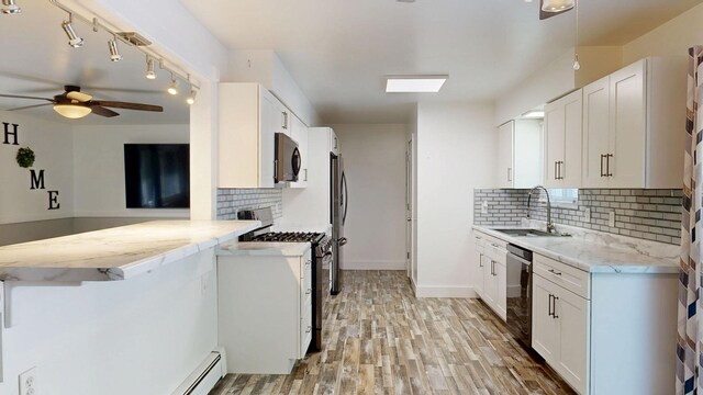11427 Colonial Woods Dr, Clio, MI 48420 - kitchen with appliances with stainless steel finishes, a ceiling fan, tasteful backsplash, and light wood finished floors