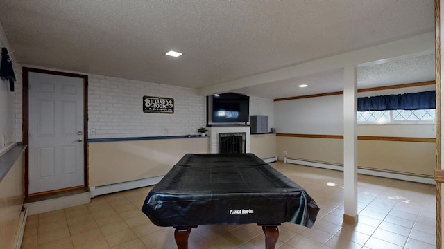 11427 Colonial Woods Dr, Clio, MI 48420 - game room with billiards, a textured ceiling, baseboard heating, a fireplace, and light tile patterned floors