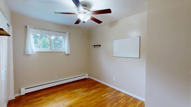 11427 Colonial Woods Dr, Clio, MI 48420 - spare room featuring baseboard heating, ceiling fan, and light wood-style flooring