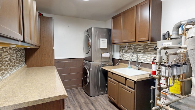 11427 Colonial Woods Dr, Clio, MI 48420 - laundry room featuring stacked washer / drying machine, light wood finished floors, a wainscoted wall, and cabinet space