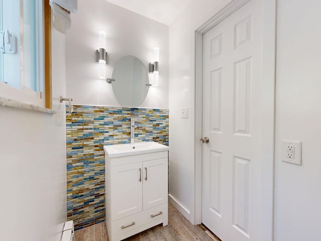 11427 Colonial Woods Dr, Clio, MI 48420 - bathroom featuring vanity, wood finished floors, and decorative backsplash