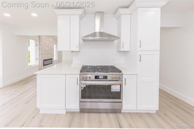3145 Point Of The Woods Dr, West Bloomfield, MI 48324 - kitchen featuring wall chimney range hood, stainless steel gas range, white cabinetry, light countertops, and light wood-type flooring
