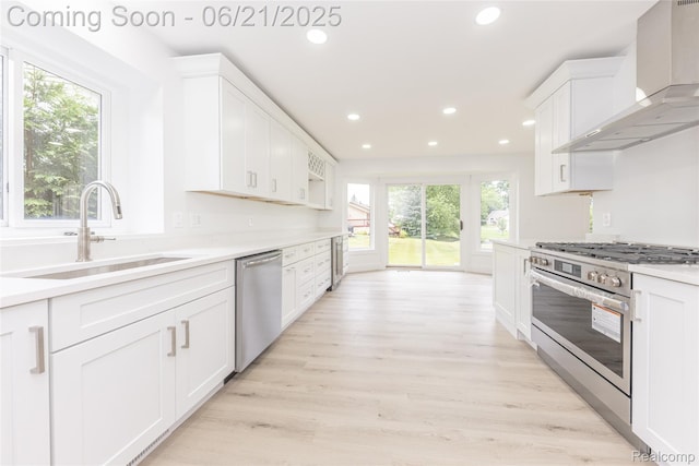 3145 Point Of The Woods Dr, West Bloomfield, MI 48324 - kitchen with appliances with stainless steel finishes, wall chimney exhaust hood, recessed lighting, white cabinets, and light countertops
