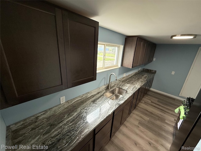 2326 Silver Cir, Pontiac, MI 48328 - kitchen featuring light wood-style flooring, dark brown cabinetry, and dark stone counters