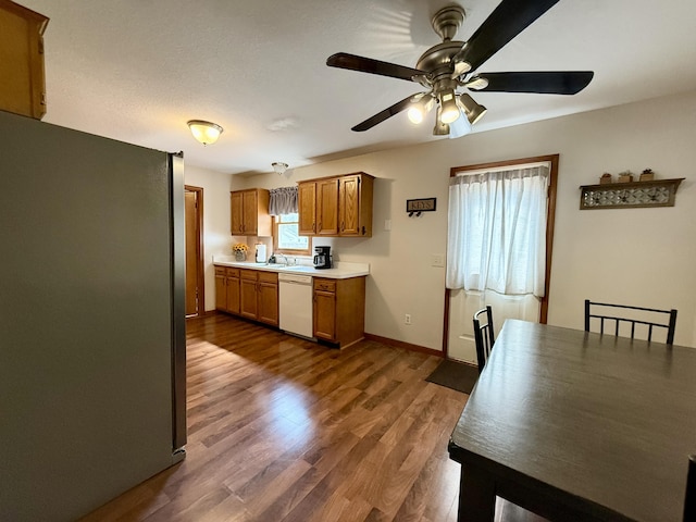 8021 Mclain Ave, Lambertville, MI 48144 - kitchen featuring freestanding refrigerator, dishwasher, ceiling fan, brown cabinetry, and light countertops