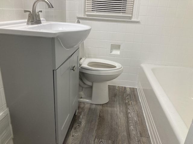 11751 Engleside St, Detroit, MI 48205 - bathroom featuring tile walls, a bathtub, wood finished floors, and vanity