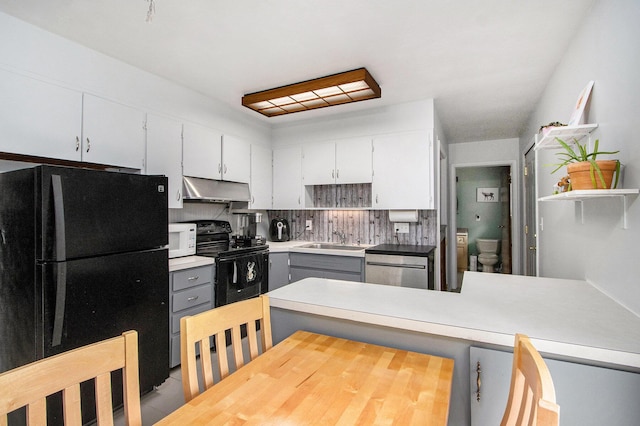 9930 N 16th St, Plainwell, MI 49080 - kitchen featuring black appliances, under cabinet range hood, gray cabinetry, light countertops, and a peninsula