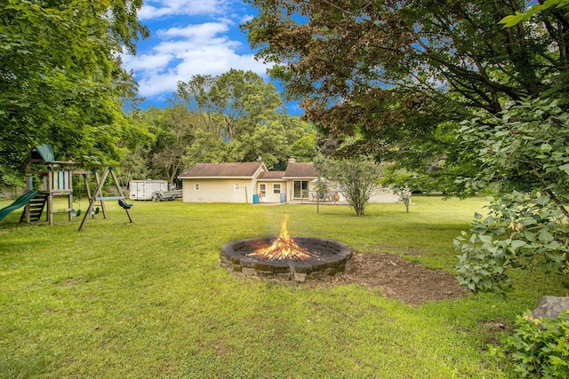 9930 N 16th St, Plainwell, MI 49080 - view of grassy yard with a fire pit, a playground, and a shed