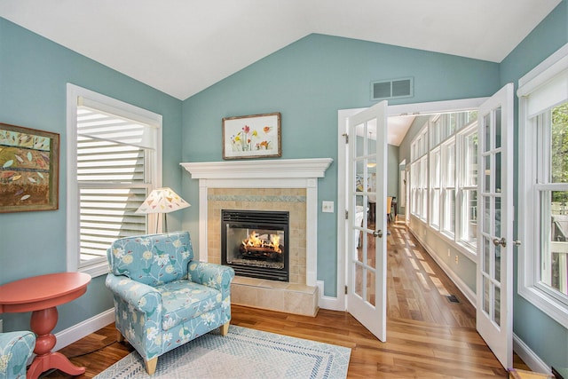 3314 Westview Ct, Allegan, MI 49010 - living area with french doors, vaulted ceiling, a tile fireplace, and wood finished floors