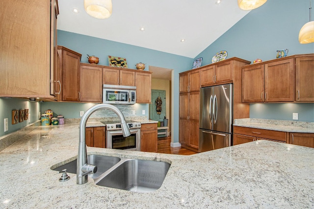 3314 Westview Ct, Allegan, MI 49010 - kitchen featuring stainless steel appliances, lofted ceiling, light stone countertops, brown cabinetry, and decorative light fixtures