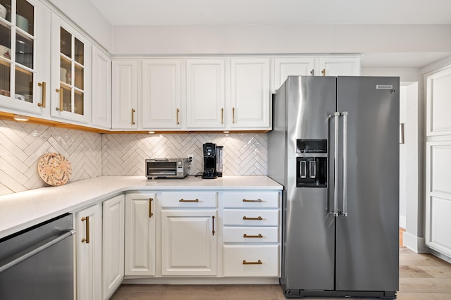 1908 Niles Ave, Saint Joseph, MI 49085 - kitchen featuring stainless steel appliances, backsplash, white cabinetry, light countertops, and light wood-type flooring