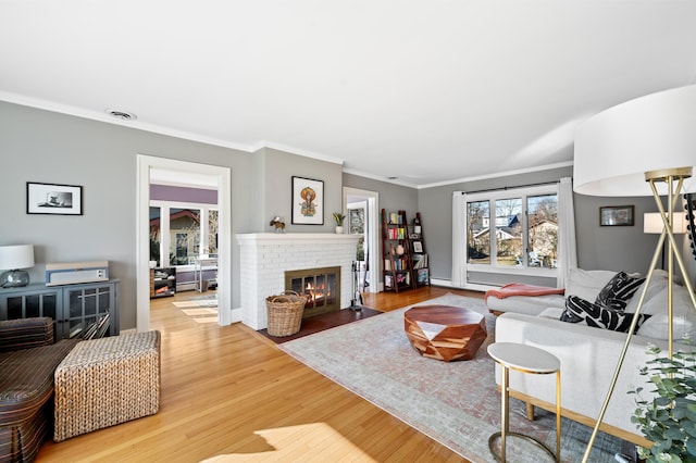 1908 Niles Ave, Saint Joseph, MI 49085 - living room featuring a brick fireplace, wood finished floors, crown molding, and a baseboard heating unit