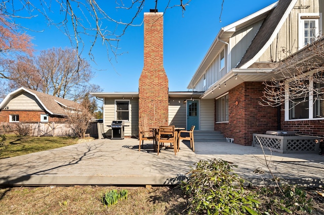 1908 Niles Ave, Saint Joseph, MI 49085 - rear view of property featuring board and batten siding, a deck, a chimney, and brick siding