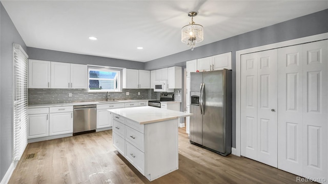 6596 Corral Ct, West Bloomfield, MI 48324 - kitchen featuring stainless steel appliances, a chandelier, white cabinets, backsplash, and recessed lighting
