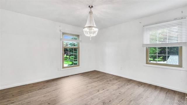 6596 Corral Ct, West Bloomfield, MI 48324 - unfurnished room with a chandelier and wood finished floors