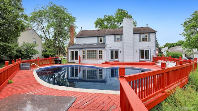 6596 Corral Ct, West Bloomfield, MI 48324 - rear view of property featuring a deck, a chimney, and an outdoor pool