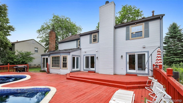 6596 Corral Ct, West Bloomfield, MI 48324 - rear view of property with a chimney, an outdoor pool, and a deck